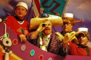 Dads in sailor hats and costumes on a Follies stage set