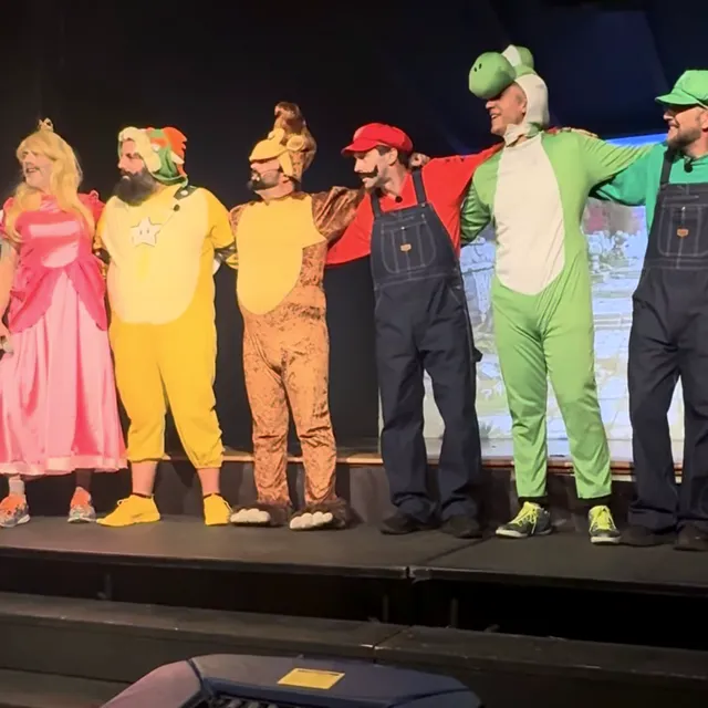Dads on stage in Super Mario costumes at the Fathers' Follies